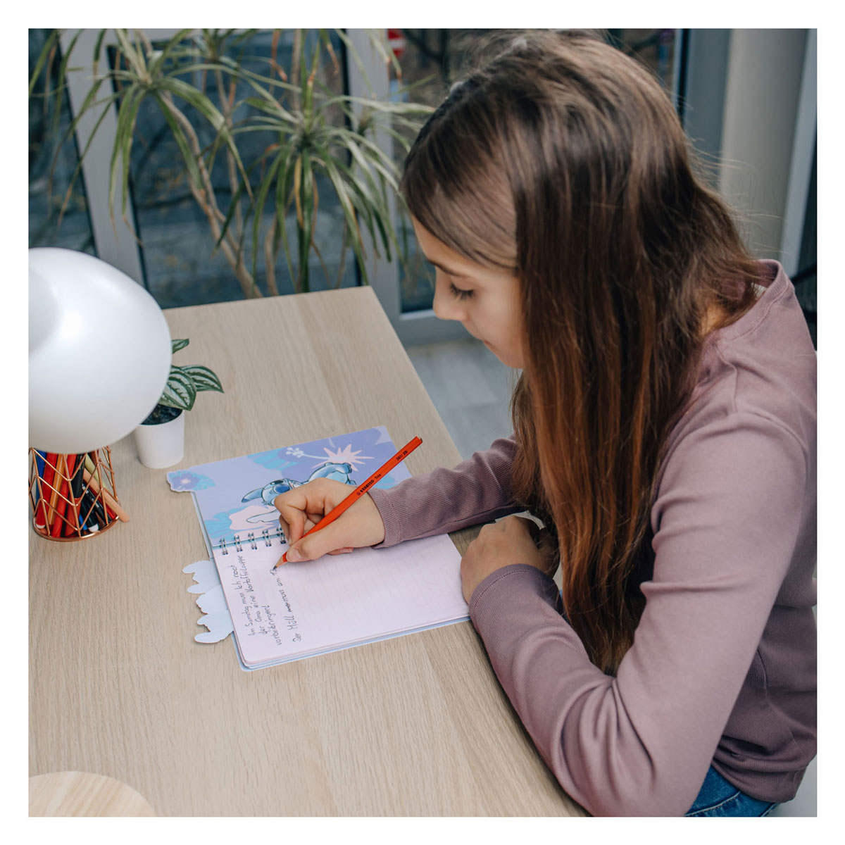 Ejemplo de uso de cuaderno espiral de la línea Disney durante escritura.