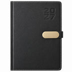 Agenda Diver Class DC/68 2027, SKU 40083-2: segunda toma de cubierta oscura con broche metálico dorado. Imagen retocada sobre blanco para retirar plástico y papel protector, con apoyo de referencia del mismo modelo.