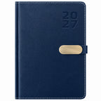 Agenda Diver Class DC/68 2027, SKU 40083-2: cubierta azul con broche metálico dorado. Imagen retocada sobre blanco para retirar plástico y papel protector, con apoyo de referencia del mismo modelo.