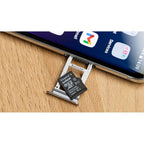 Ejemplo de uso de una tarjeta microSD insertándose en la bandeja de memoria de un teléfono.
