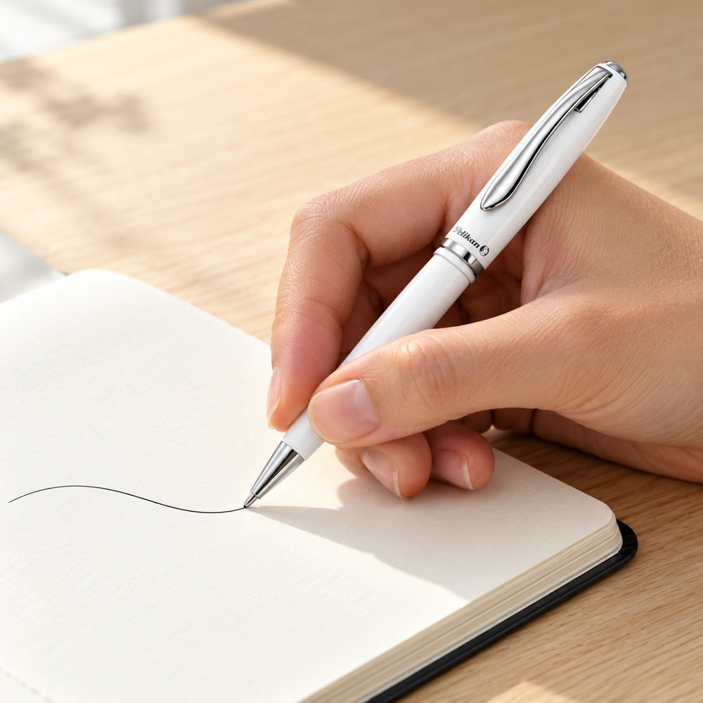 Bolígrafo Pelikan Jazz Elegance Blanco de Tinta Negra. Ejemplo ilustrativo de uso generado con IA; los elementos del entorno no indican accesorios incluidos.